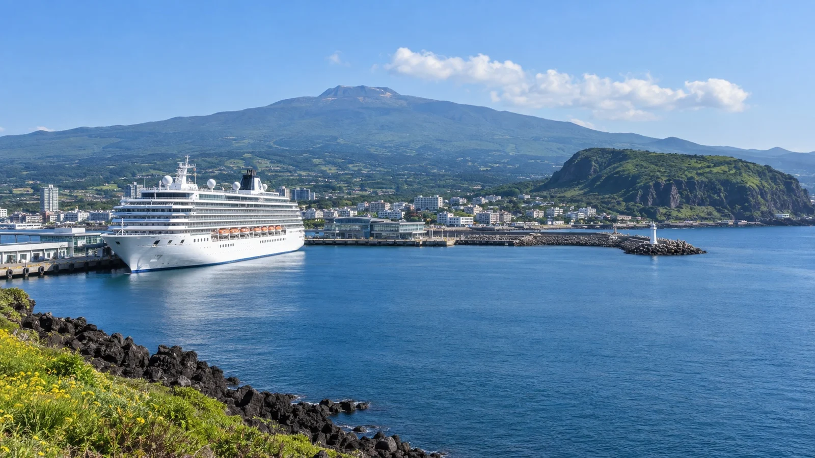 Cruise ship at Jeju Island harbor with volcanic coastal scenery in South Korea