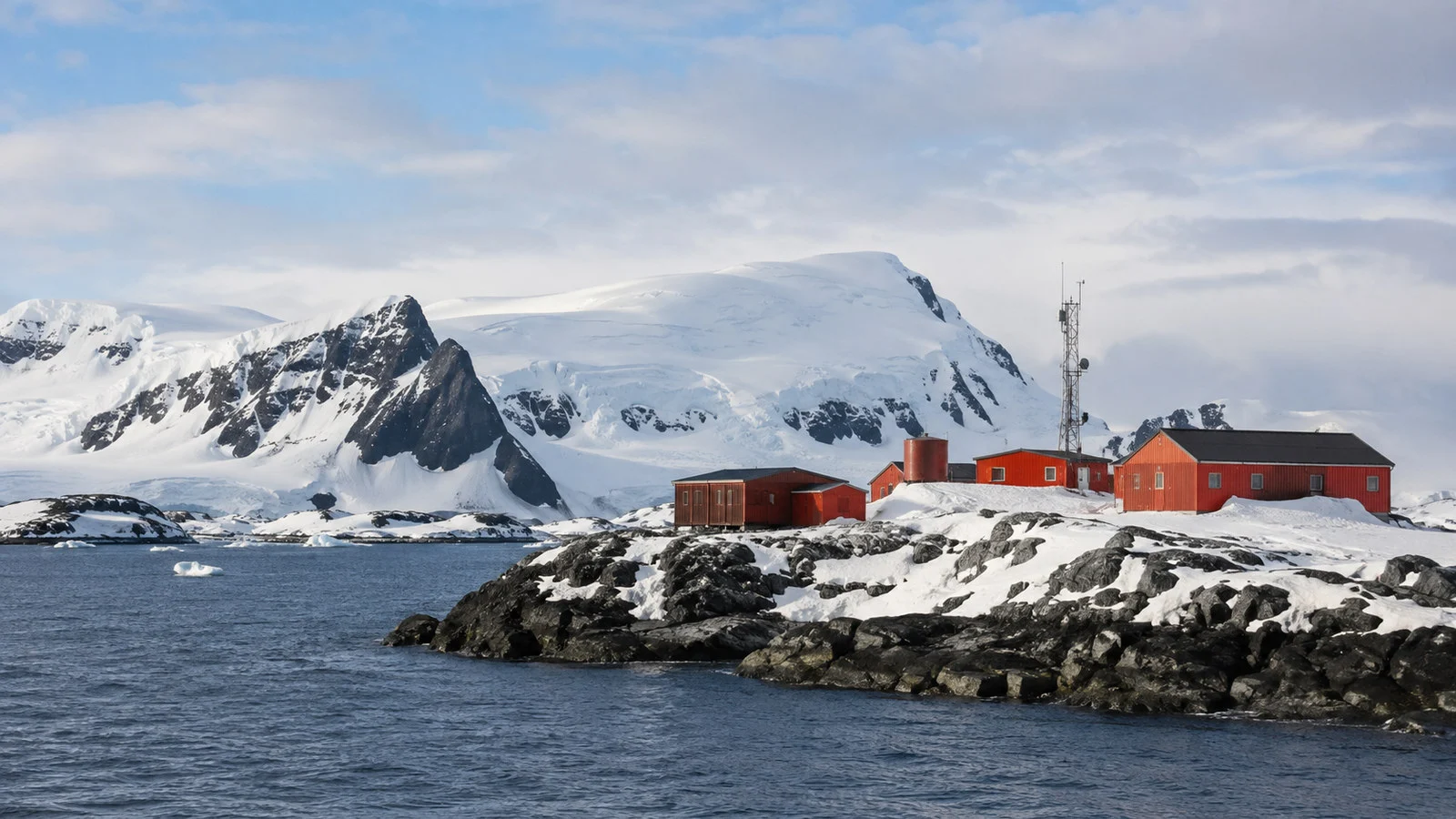 Remote South Shetland Islands Antarctic research station low buildings on snow and rock beside sea, no people