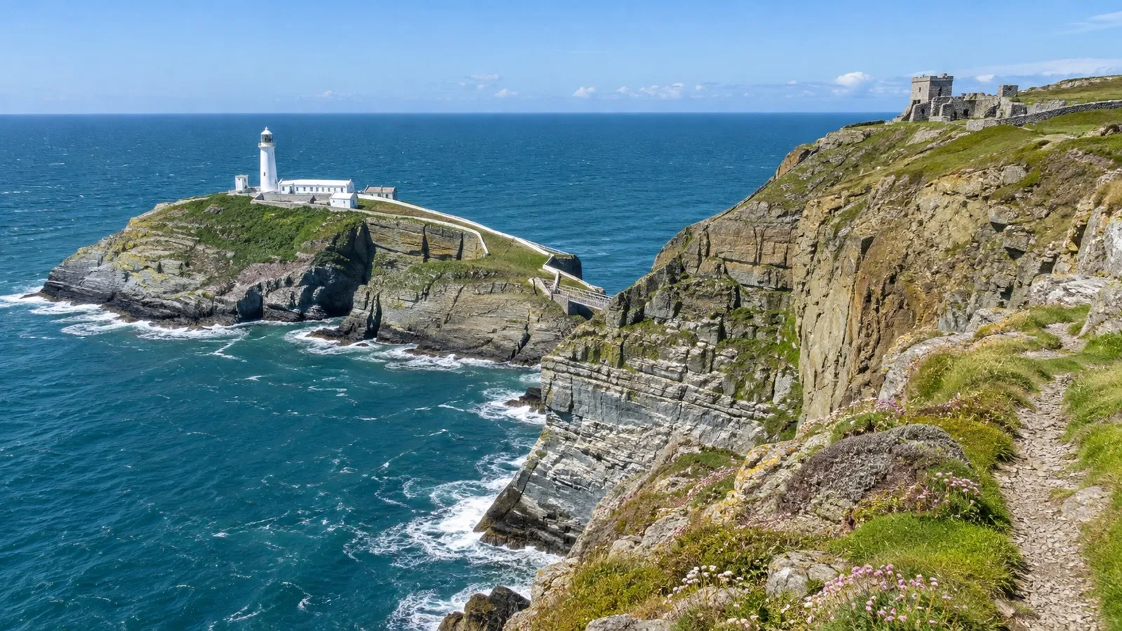South Stack Lighthouse on rocky island below Anglesey cliffs