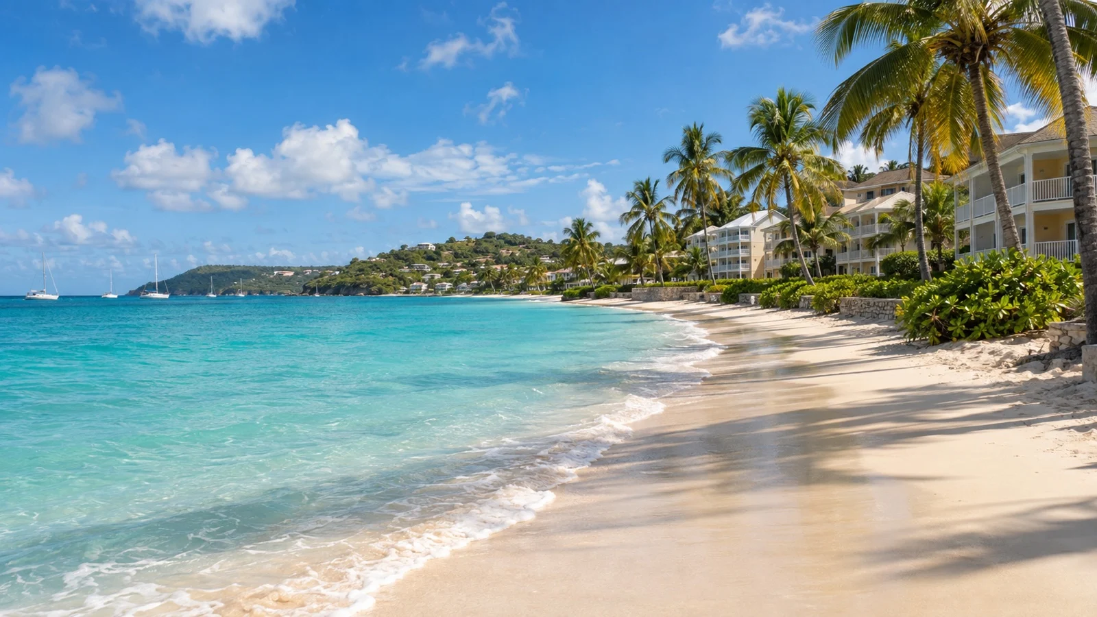 Dickenson Bay in Antigua with beachfront apartment hotels, palms and turquoise Caribbean water