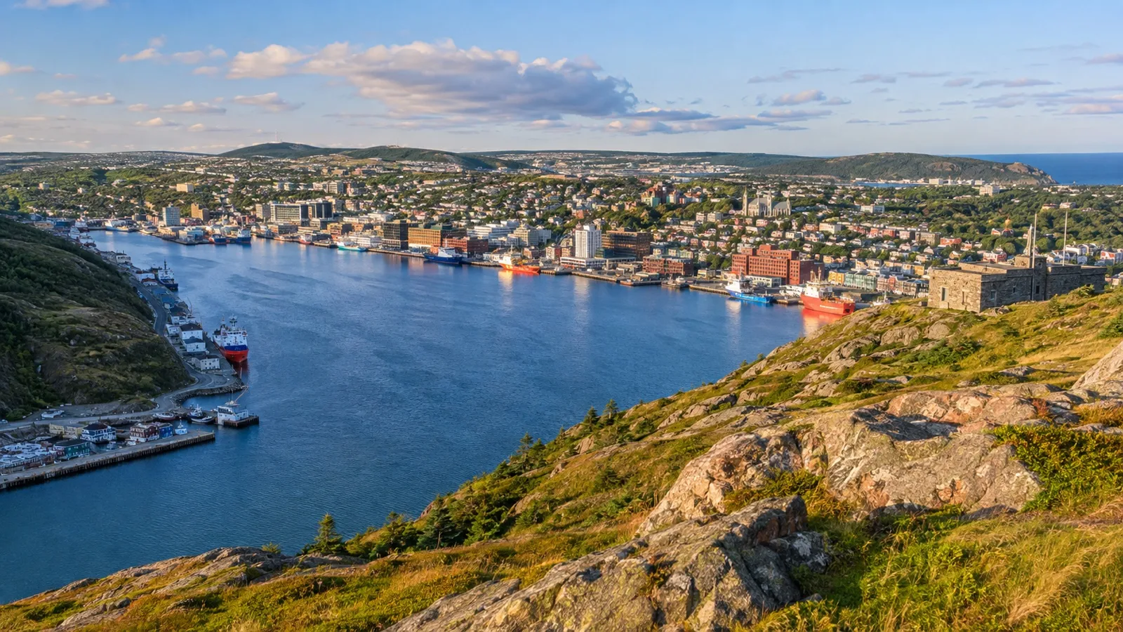 Panoramic view over St. John's harbor from Signal Hill with colorful downtown houses and Atlantic coastline