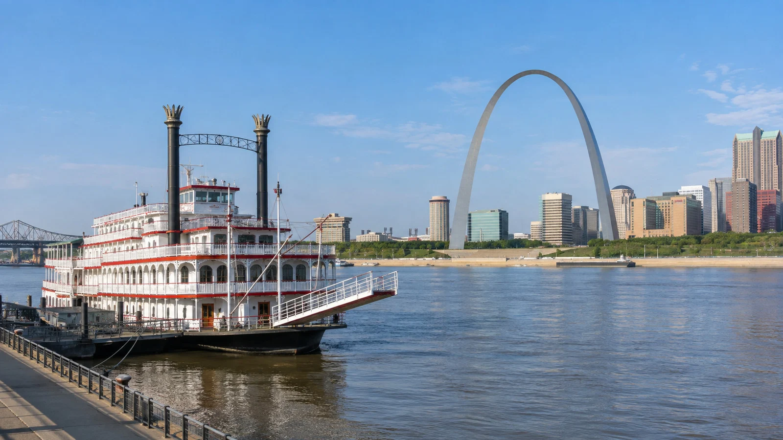 Tom Sawyer riverboat moored at the St. Louis Mississippi River waterfront with Gateway Arch in the background