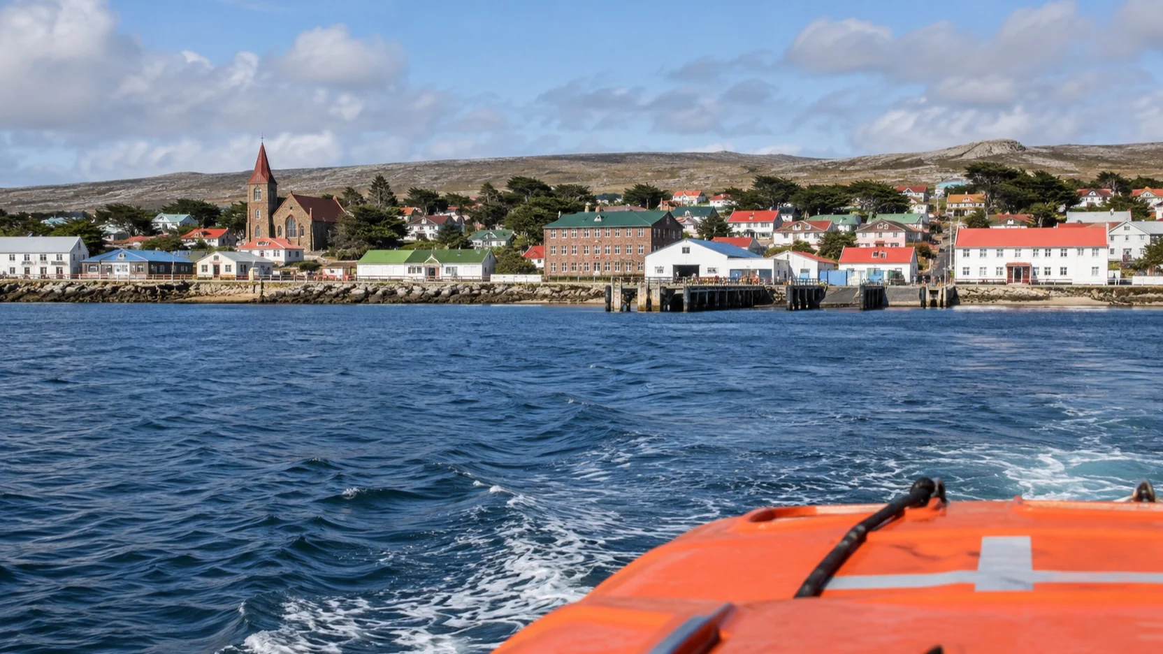 Tender approaching Stanley harbor and its colorful waterfront