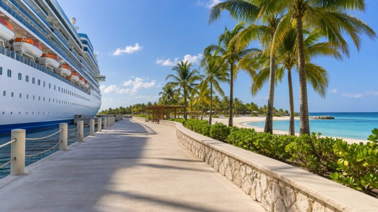 Wide stroller-friendly walkway from a cruise ship toward a tropical beach
