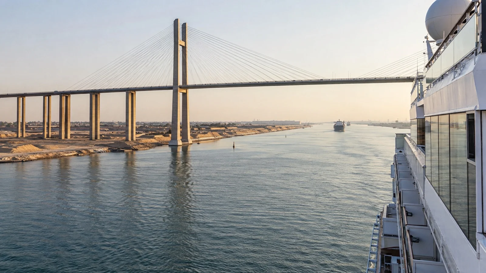 Cruise ship passing beneath large Suez Canal road bridge