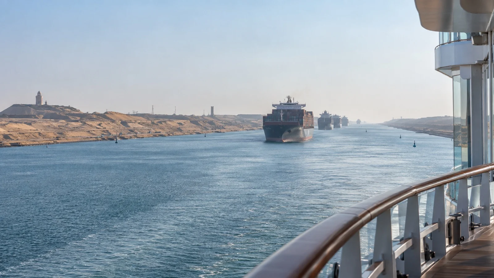 Cargo ships traveling in the Suez Canal, seen from an empty cruise ship deck