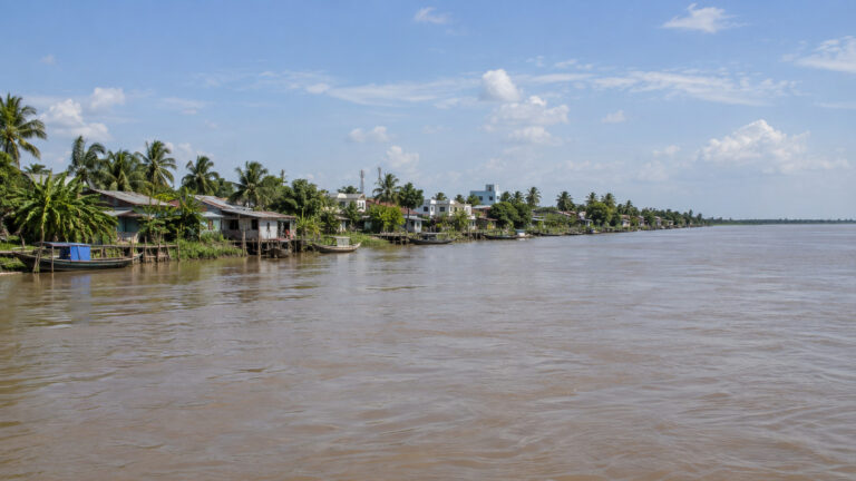 Wide flat Tiền River flowing past Tân Châu in the Mekong Delta