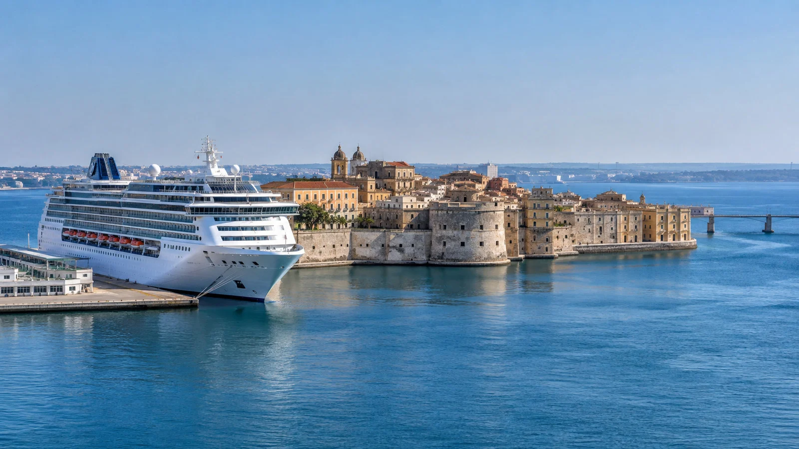 Cruise vessel at Taranto Italy port waterfront with Old Town island and blue Ionian Sea, no people
