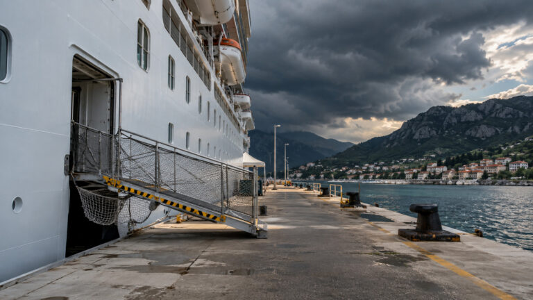 Empty cruise ship gangway closed under approaching thunderclouds
