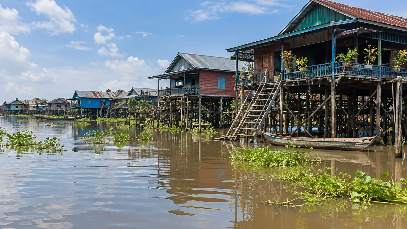 wooden stilt houses raised above seasonally flooded shore near Cambodia's Tonle Sap Lake