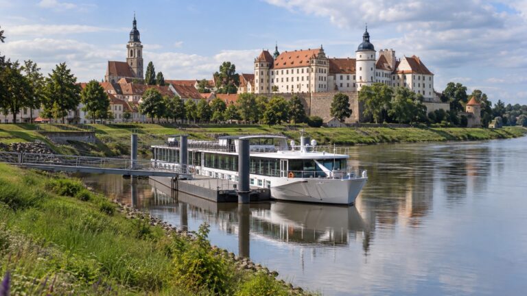 River cruise ship moored on the Elbe below the Torgau castle and church skyline