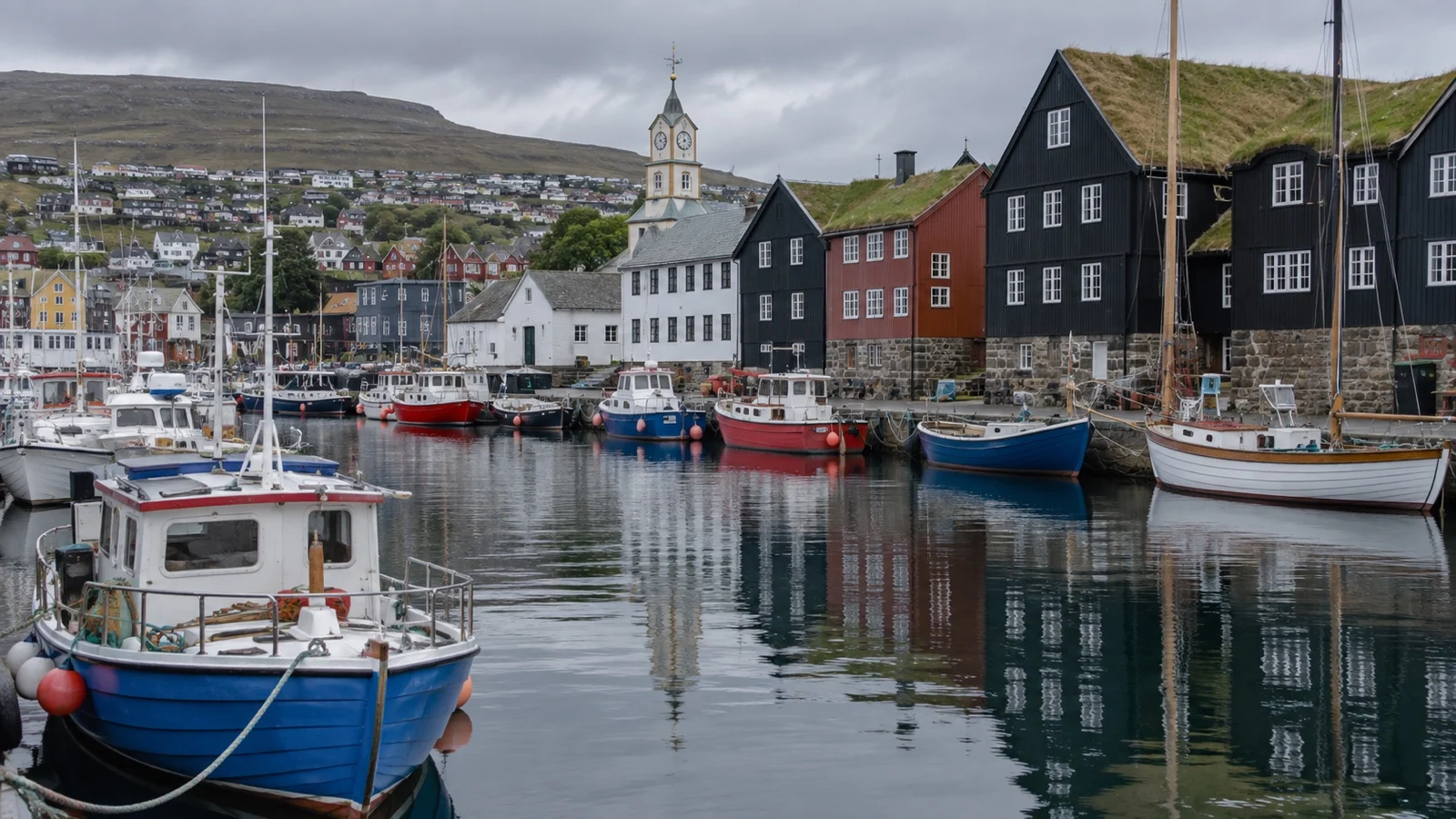 Boats and dark wooden buildings around Tórshavn inner harbor