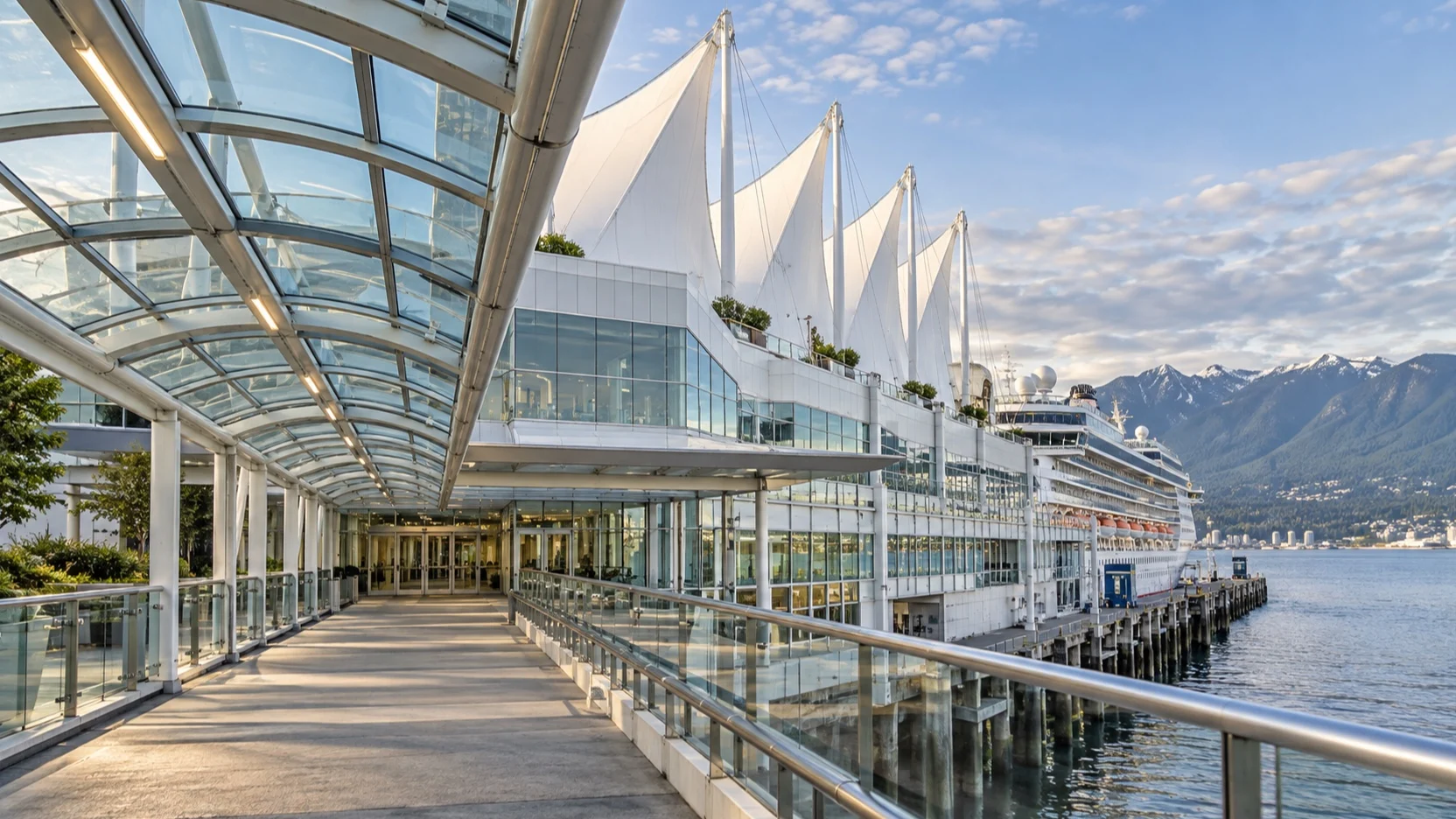 Covered passenger walkway leading to the Canada Place cruise terminal beside a docked ship