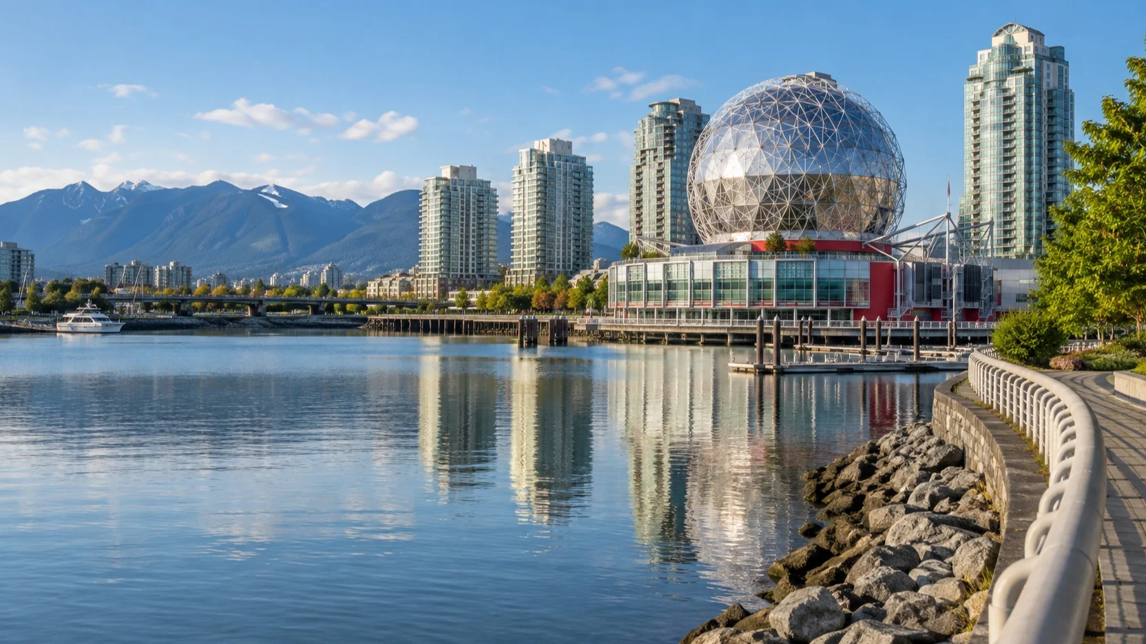 Science World’s geodesic dome beside False Creek with Vancouver towers and mountains beyond