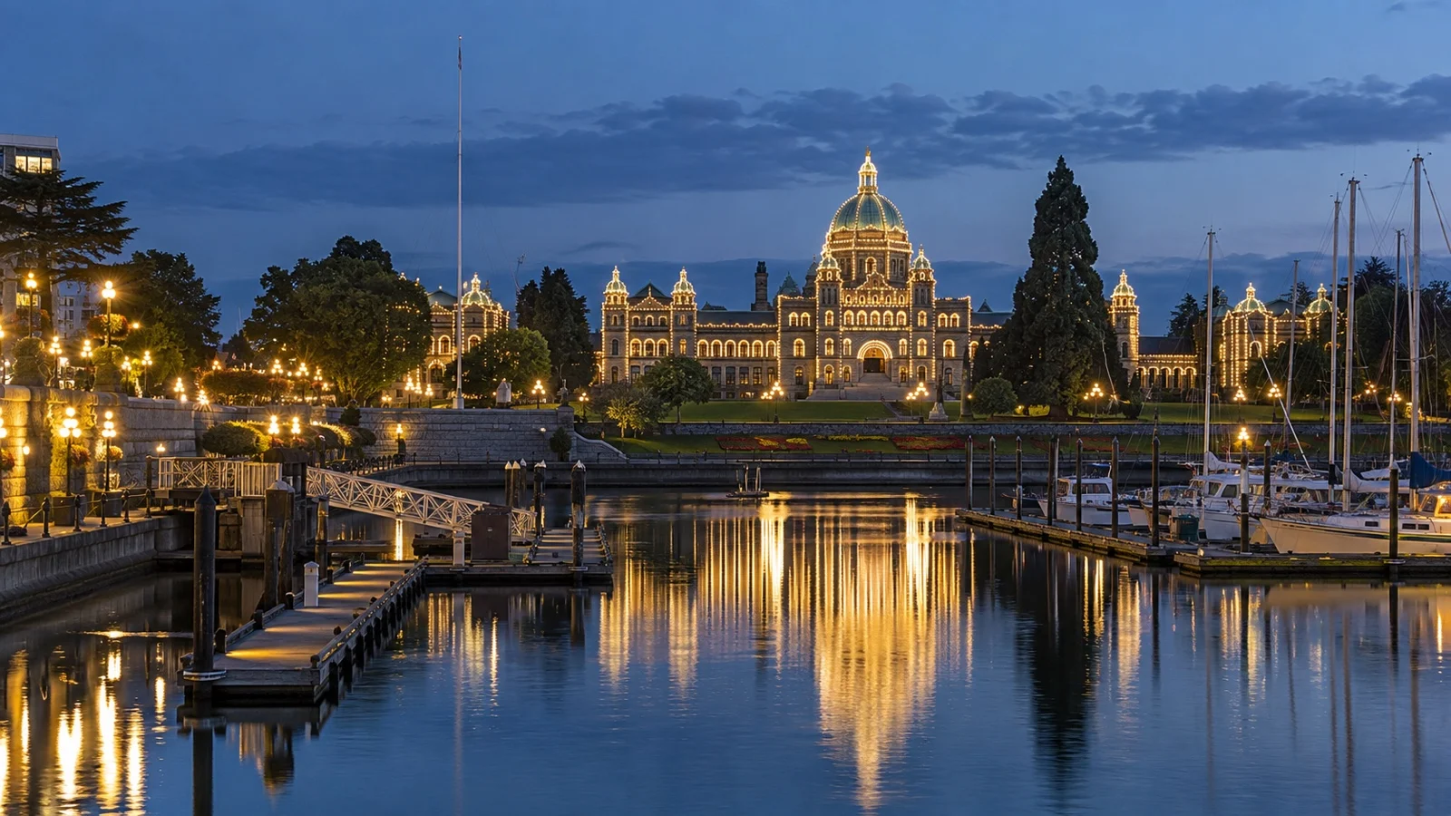 Empty Victoria Inner Harbour waterfront with Parliament Buildings glowing after sunset