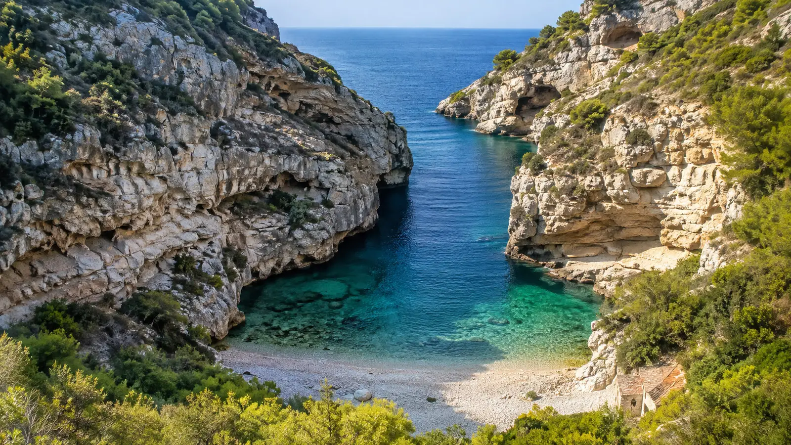 Secluded Stiniva Cove Vis Croatia narrow rocky entrance opening to pebble beach and blue water, no people
