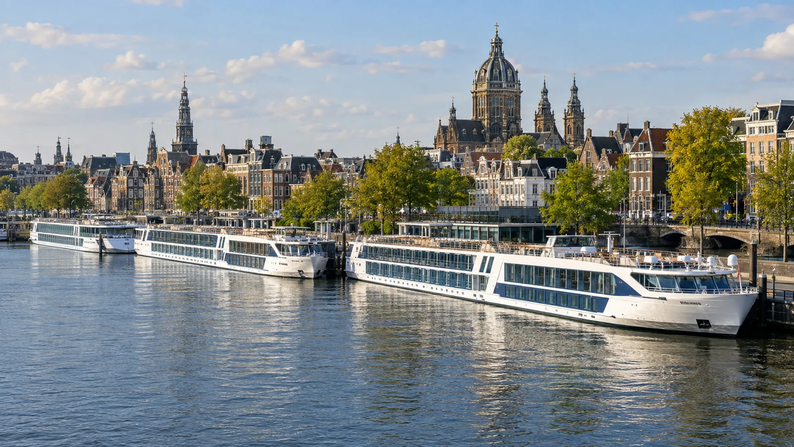 river cruise ships moored at Amsterdam's riverfront with city buildings and canals behind